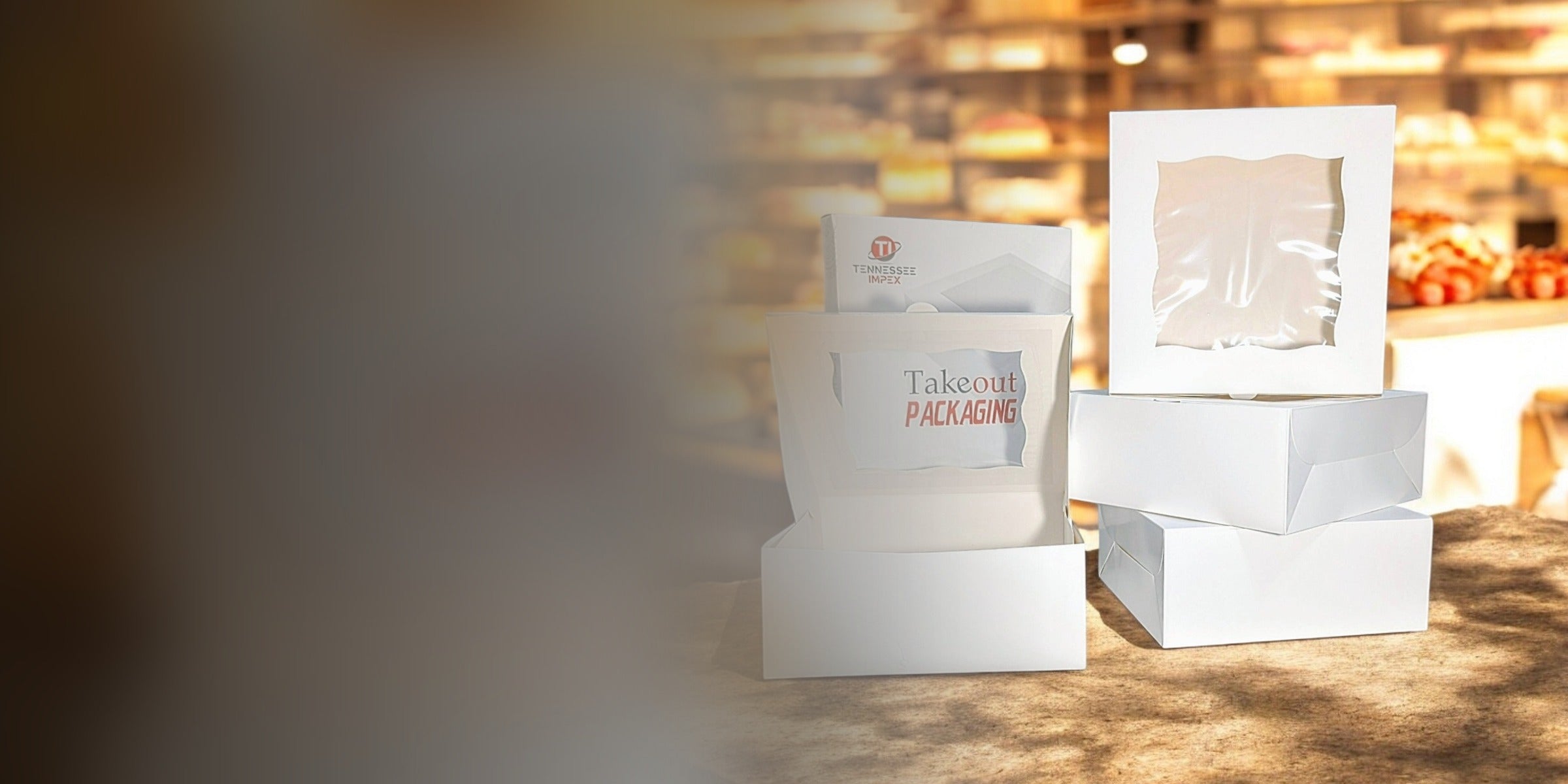 Tennessee IMPEX white cake boxes with clear windows on a bakery counter